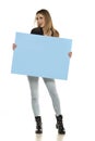 Portrait of attractive young beautiful woman holding blank blue billboard Royalty Free Stock Photo