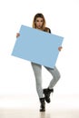 Portrait of attractive young beautiful woman holding blank blue billboard Royalty Free Stock Photo