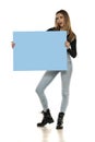 Portrait of attractive young beautiful woman holding blank blue billboard Royalty Free Stock Photo