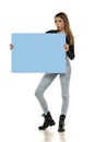 Portrait of attractive young beautiful woman holding blank blue billboard Royalty Free Stock Photo