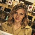 Portrait of Attractive Young Blonde Woman in Trench visiting Shop