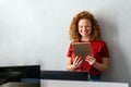 Portrait of an attractive young businesswoman smiling working on digital tablet in office Royalty Free Stock Photo