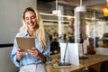 Portrait of an attractive young businesswoman smiling working on digital tablet in office Royalty Free Stock Photo