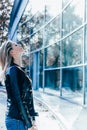 Portrait of attractive young caucasian blonde woman standing with closed eyes in front of business building Royalty Free Stock Photo