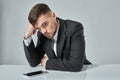 Portrait of attractive young caucasian man using cellular phone while sitting at office table. Royalty Free Stock Photo