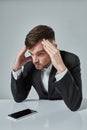 Portrait of attractive young caucasian man using cellular phone while sitting at office table. Royalty Free Stock Photo