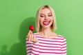 Portrait of attractive young girl lick teeth look addiction eating sweets fresh fruits strawberry isolated on green Royalty Free Stock Photo