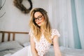 Portrait of attractive young happy caucasian woman in glasses, sitting in cozy bedroom Royalty Free Stock Photo