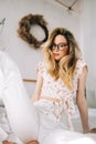 Portrait of attractive young happy caucasian woman in glasses, sitting in cozy bedroom Royalty Free Stock Photo