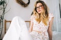 Portrait of attractive young happy caucasian woman in glasses, sitting in cozy bedroom Royalty Free Stock Photo