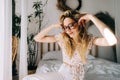 Portrait of attractive young happy caucasian woman in glasses, sitting in cozy bedroom Royalty Free Stock Photo