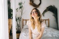 Portrait of attractive young happy caucasian woman in glasses, sitting in cozy bedroom Royalty Free Stock Photo