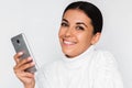 Portrait of attractive young happy woman with mobile phone with pretty toothy smile, on the white background. Royalty Free Stock Photo