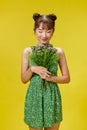 Portrait of an attractive young lady hands hold bouquet wild flowers isolated on yellow background Royalty Free Stock Photo