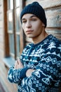 Portrait of an attractive young man with beautiful blue eyes with tanned skin in a winter blue hat in a knitted sweater Royalty Free Stock Photo