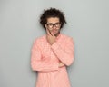 attractive young man with glasses folding arms and touching face Royalty Free Stock Photo