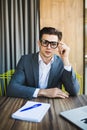 Portrait of attractive young man in glasses sitting at office desk with laptop computer Royalty Free Stock Photo