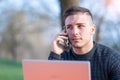 Portrait of attractive young office worker in casual wear, he received a phone call on his cellphone, he is concentrated while Royalty Free Stock Photo