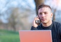 Portrait of attractive young office worker in casual wear, he received a phone call on his cellphone, he is concentrated while Royalty Free Stock Photo