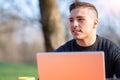 Portrait of attractive young office worker in casual wear, smiling in a break moment. He works remotely with the laptop from a Royalty Free Stock Photo