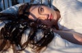 Portrait of an attractive, young, sexy, seductive dark brown haired woman in Bed, snowflakes on her long hair Royalty Free Stock Photo