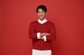 Portrait of attractive young southeast Asian man standing with crossed arms isolated on red background Royalty Free Stock Photo