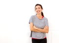 Attractive young sports woman smiling with arms crossed against white wall Royalty Free Stock Photo