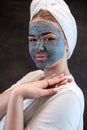 Portrait of attractive young woman apply clay mud mask on her face isolated on black Royalty Free Stock Photo