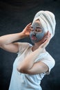 Portrait of attractive young woman apply clay mud mask on her face isolated on black Royalty Free Stock Photo