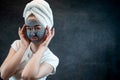 Portrait of attractive young woman apply clay mud mask on her face isolated on black Royalty Free Stock Photo