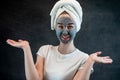 Portrait of attractive young woman apply clay mud mask on her face isolated on black Royalty Free Stock Photo