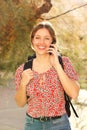 Attractive young woman with backpack talking on mobile phone