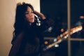 Portrait of attractive young woman in black cocktail dress leaning on wall Royalty Free Stock Photo