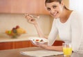 Enjoying a healthy breakfast. Portrait of an attractive young woman eating her breakfast in the kitchen. Royalty Free Stock Photo