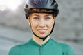 Portrait of attractive young woman, female cyclist wearing biking helmet smiling at camera while posing outdoors on a Royalty Free Stock Photo