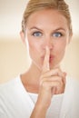 Keep this a secret. Portrait of an attractive young woman gesturing for you to be quiet. Royalty Free Stock Photo