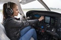 Portrait of Attractive Young Woman Pilot With Headset in the Cockpit