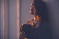 Portrait of an attractive young woman in profile in the rays of the sun in profile with a happy smile holding a hat in her hands Royalty Free Stock Photo