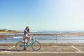 My bike, the sea and me. Portrait of an attractive young woman riding her bicycle outside. Royalty Free Stock Photo