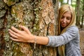 Close up portrait of a young nature lover woman, hugging a big pine tree Royalty Free Stock Photo