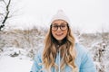 Portrait of attractive young woman standing in a winter park after snowfall Royalty Free Stock Photo