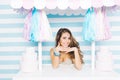 Portrait attractive young woman in summer dress with long brunette curly hair smiling to camera from sweets truck on Royalty Free Stock Photo