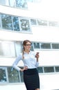 Portrait of an attractive young woman walking and looking at mobile phone Royalty Free Stock Photo