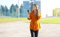 Portrait of attractive young woman walking outside and reading text message on cell phone