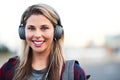 Jamming away in the city. Portrait of an attractive young woman wearing headphones while walking through the city. Royalty Free Stock Photo