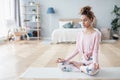 Portrait of attractive young woman working out at home, doing yoga exercise on white mat Royalty Free Stock Photo