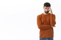 Portrait of awkward and embarrassed bearded man pretend he not see his ex, hiding face behind hand, facepalm and peek Royalty Free Stock Photo
