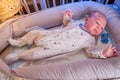 Portrait of a baby boy aged 1 month lying with his eyes open in a crib. Caucasian child in the children bedroom on the bed Royalty Free Stock Photo