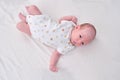 Portrait of a baby boy aged 1 month lying with his eyes open in a crib. Caucasian child in the children bedroom on the bed Royalty Free Stock Photo