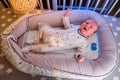 Portrait of a baby boy aged one month crying in a crib. Caucasian screaming child in the children bedroom on the bed Royalty Free Stock Photo